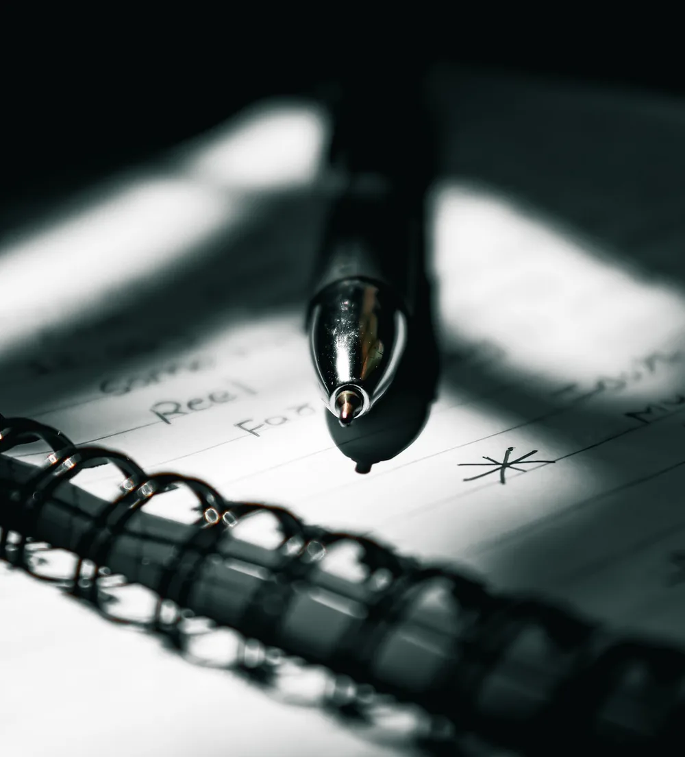 Pen resting on a notebook of handwritten notes