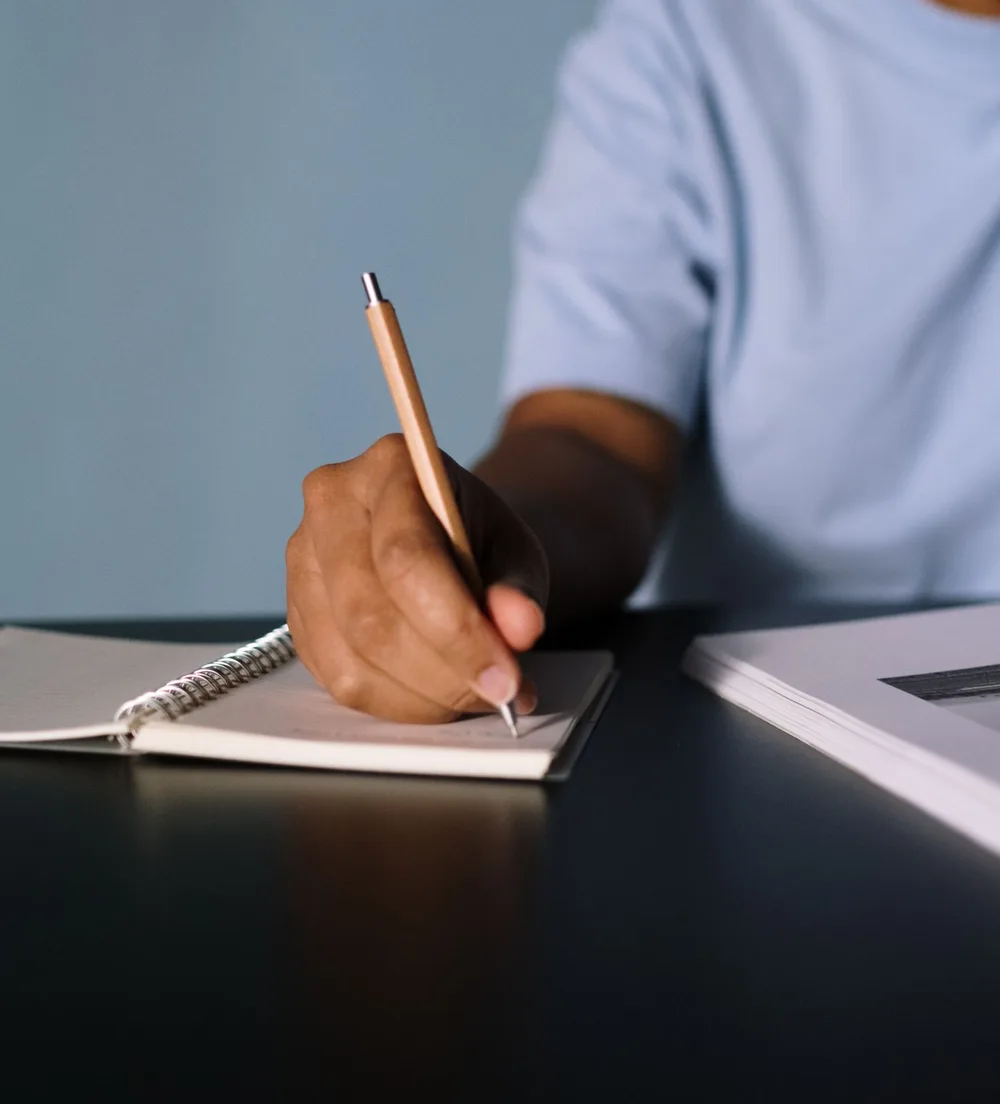 A hand writing in a notebook