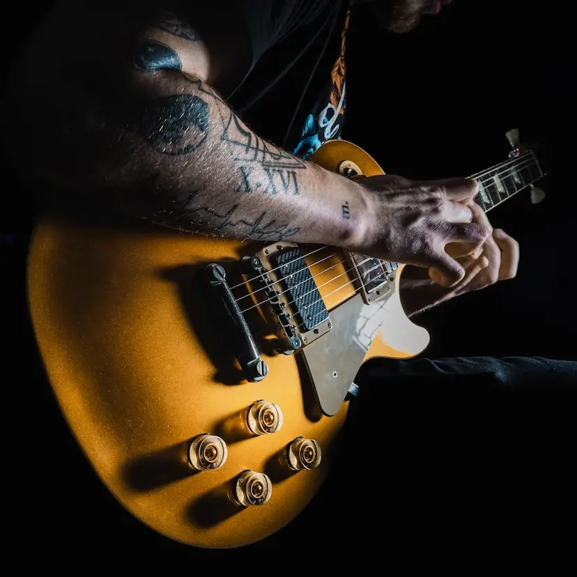 Close-up of a musician playing a yellow electric guitar